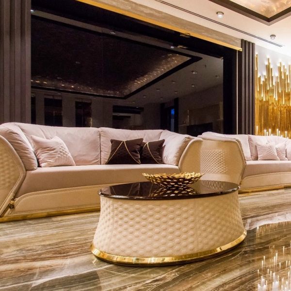 Luxurious beige sofas with gold accents in an elegant living room.