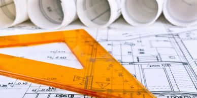 Orange triangle ruler on architectural blueprints.