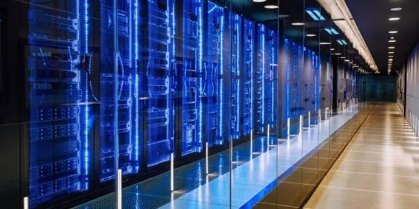 Modern data center hallway with illuminated server racks.