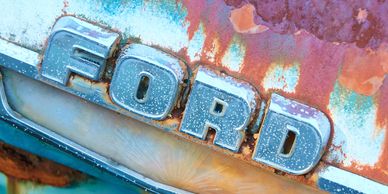 A rainbow of colours emerge from a vintage Ford badge as it the corrosion attempts to reduce it back