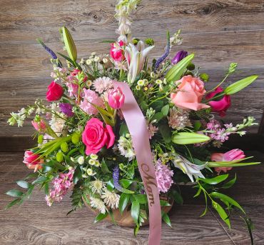 Colorful floral arrangement with a pink 'Mom' ribbon.