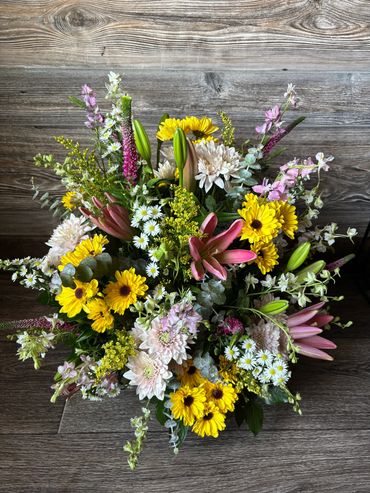 Colorful mixed flower bouquet with yellow, pink, and white blooms.