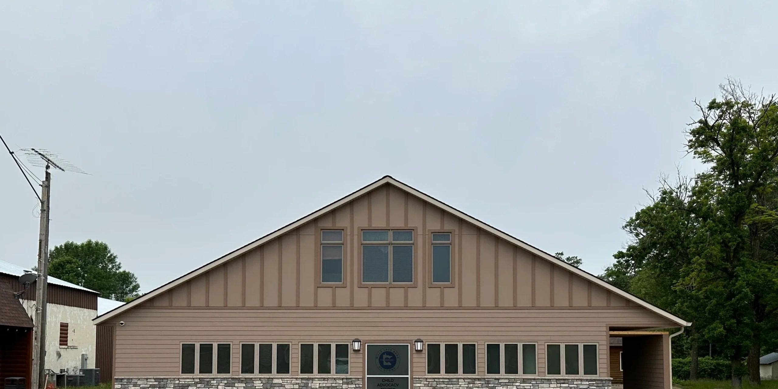 Front view of a Child Advocacy Center building with a stone base and beige siding.