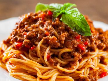 Plato de espaguetis con salsa de ragú a la boloñesa y queso parmesano.