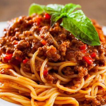 Plato de espaguetis con salsa de ragú a la boloñesa y queso parmesano.
