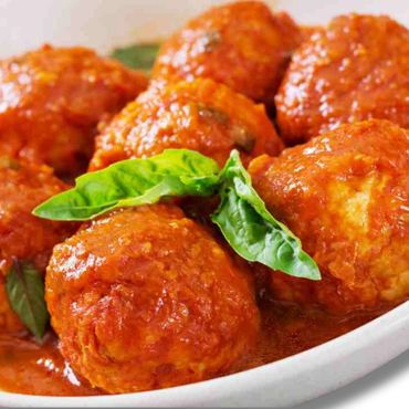 Un primer plano de suculentas albóndigas cubiertas con una rica salsa de tomate.