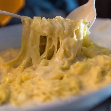 Plato de pasta fettuccine con salsa Alfredo original, hecha con mantequilla y queso.