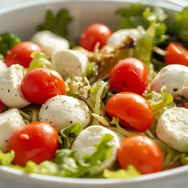 Una vibrante ensaladera llena de verduras frescas, tomates cherry y cremosas bolas de mozzarella.