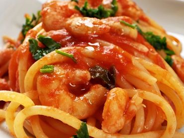 Plato de espaguetis con camarones y salsa de tomate.