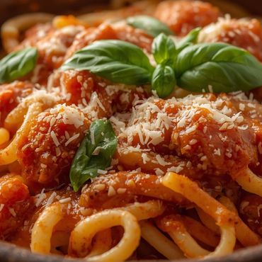 Plato de espaguetis con salsa de tomate fresco, albahaca y queso parmesano.