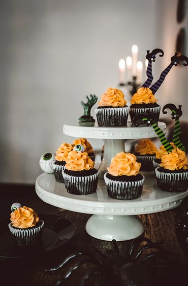 halloween cupcakes on stacked white cake stands with halloween decor made by Chicago Food Stylist Ni