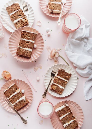 Cake slices on scalloped plates on a pink background made by Chicago Food Stylist Nicole Triebe