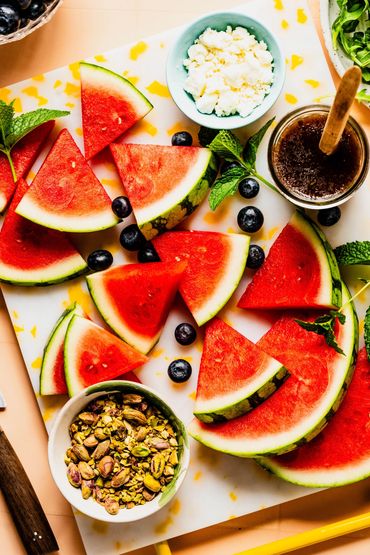 Fresh watermelon slices with blueberries, pistachios, honey, and cottage cheese.