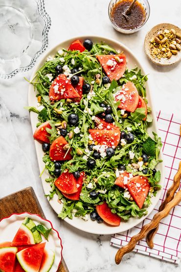 Fresh watermelon and blueberry salad with greens and feta cheese.