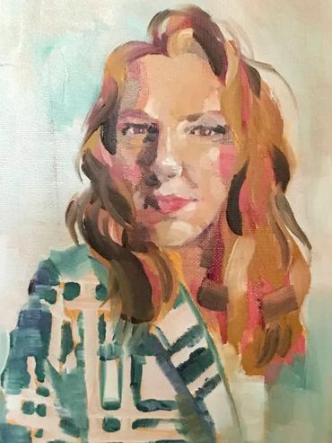 Woman with red hair smiling, wearing a plaid blazer