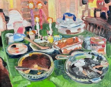 a thanksgiving feast with lit candles laid out on a green tablecloth