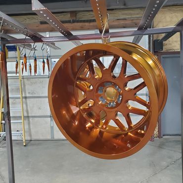 Metal car rims hanging for drying or painting.