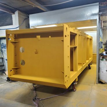 Large industrial yellow metal frame inside a workshop.