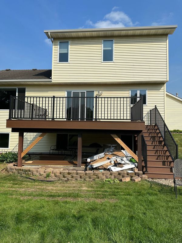 brown deck, black banisters, yellow house.