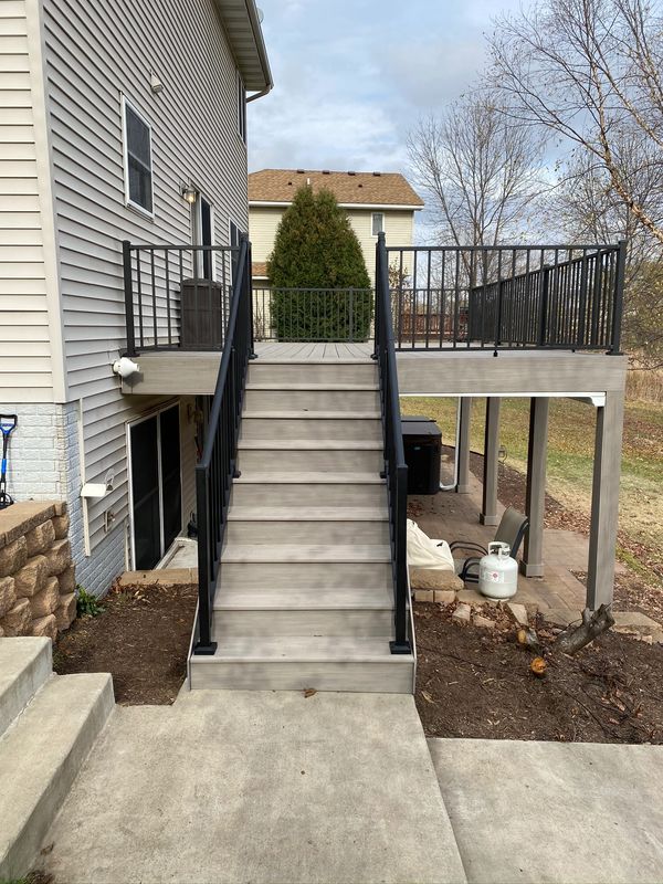 cement deck, cement stairs, black banister, 4 footings.