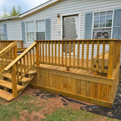 Newly built wooden deck and stairs in front of a house.