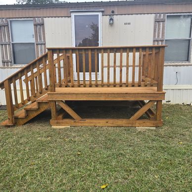Wooden deck and stairs attached to a mobile home.