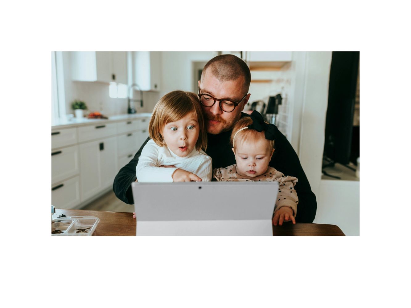Picture of a man with his children looking at a computer screen.
