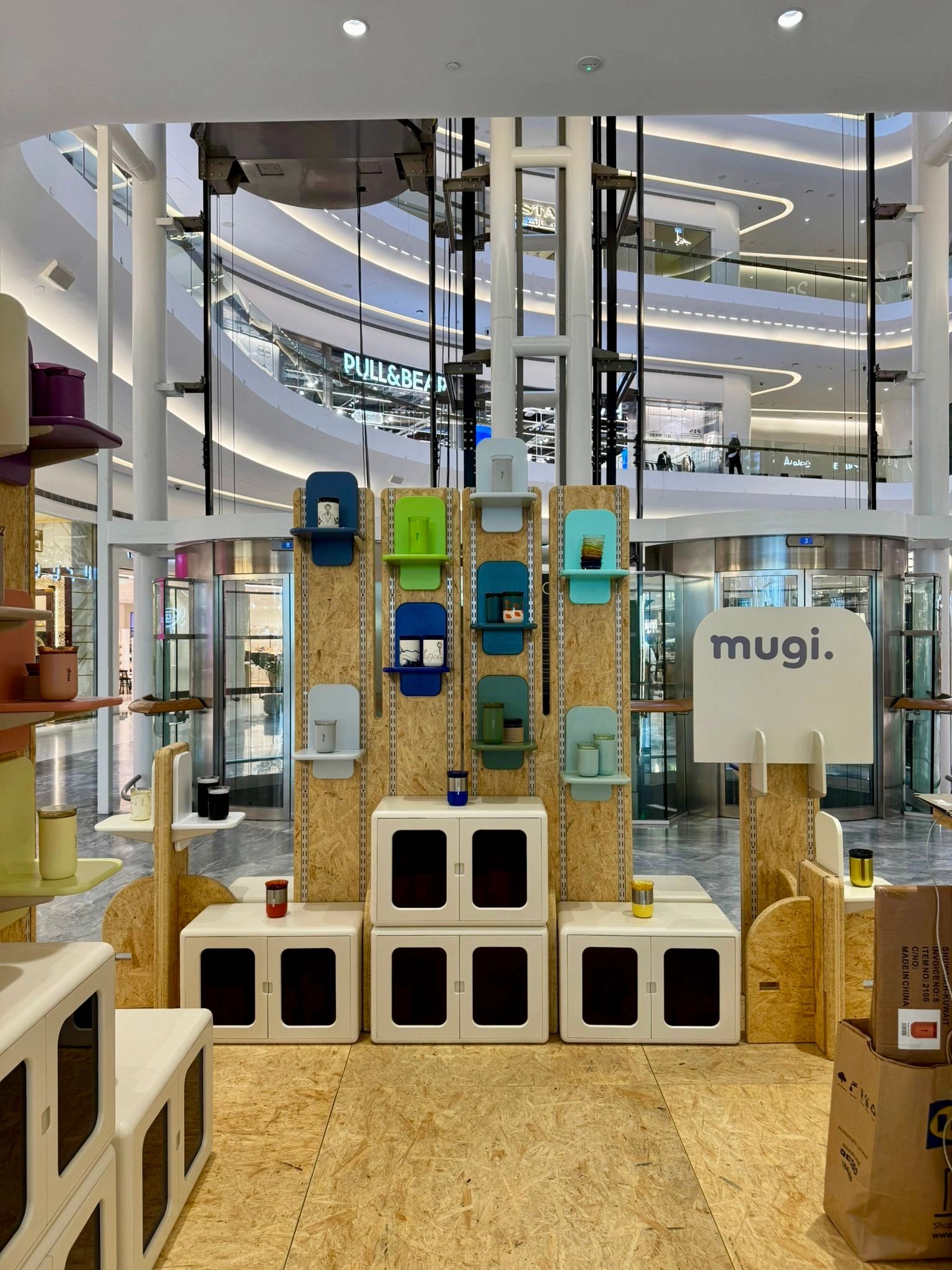 Display of colorful mugs in a modern shopping mall.