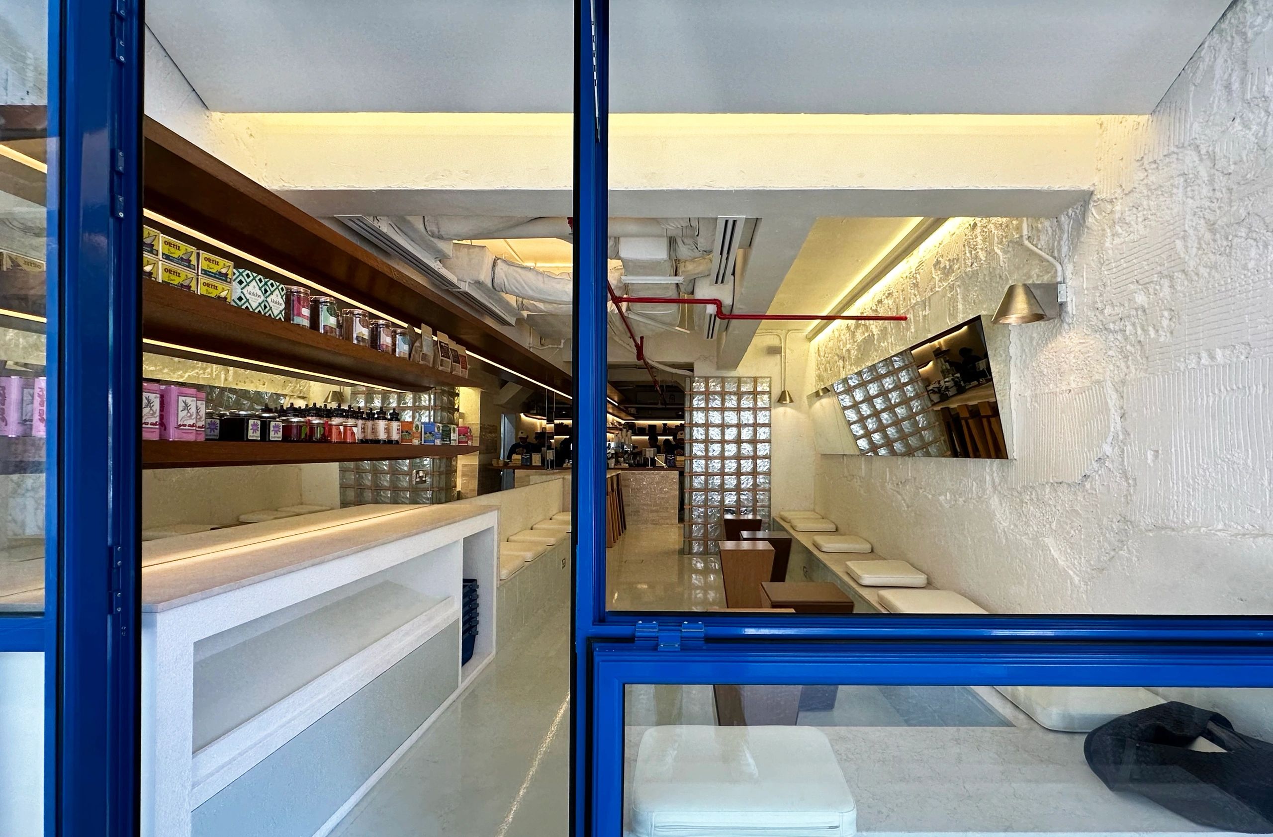 Modern cafe interior with blue window frames and cozy seating.