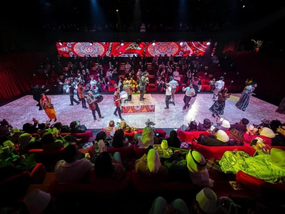 A live cultural performance with musicians and dancers on stage.