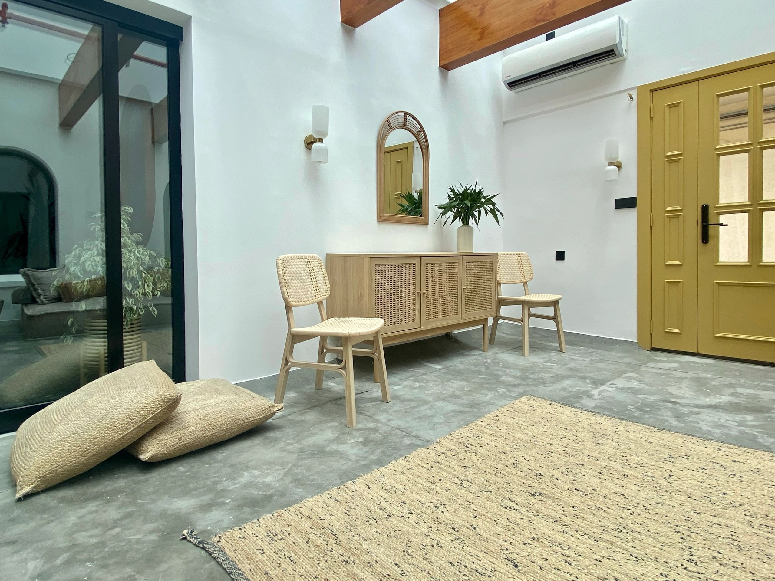 Minimalist room with wooden chairs and a sideboard.
