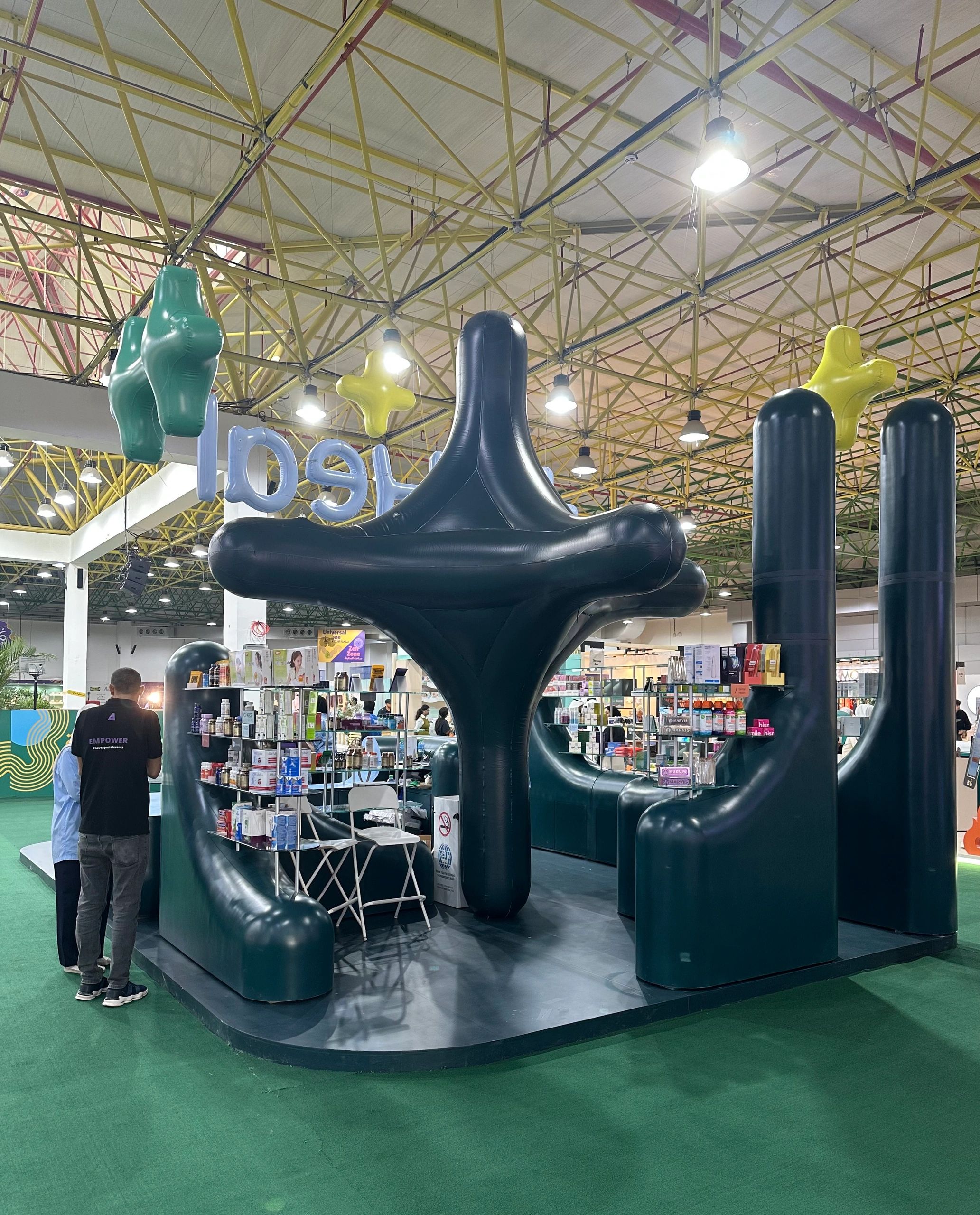 Modern exhibition booth with large black and yellow inflatable structures.