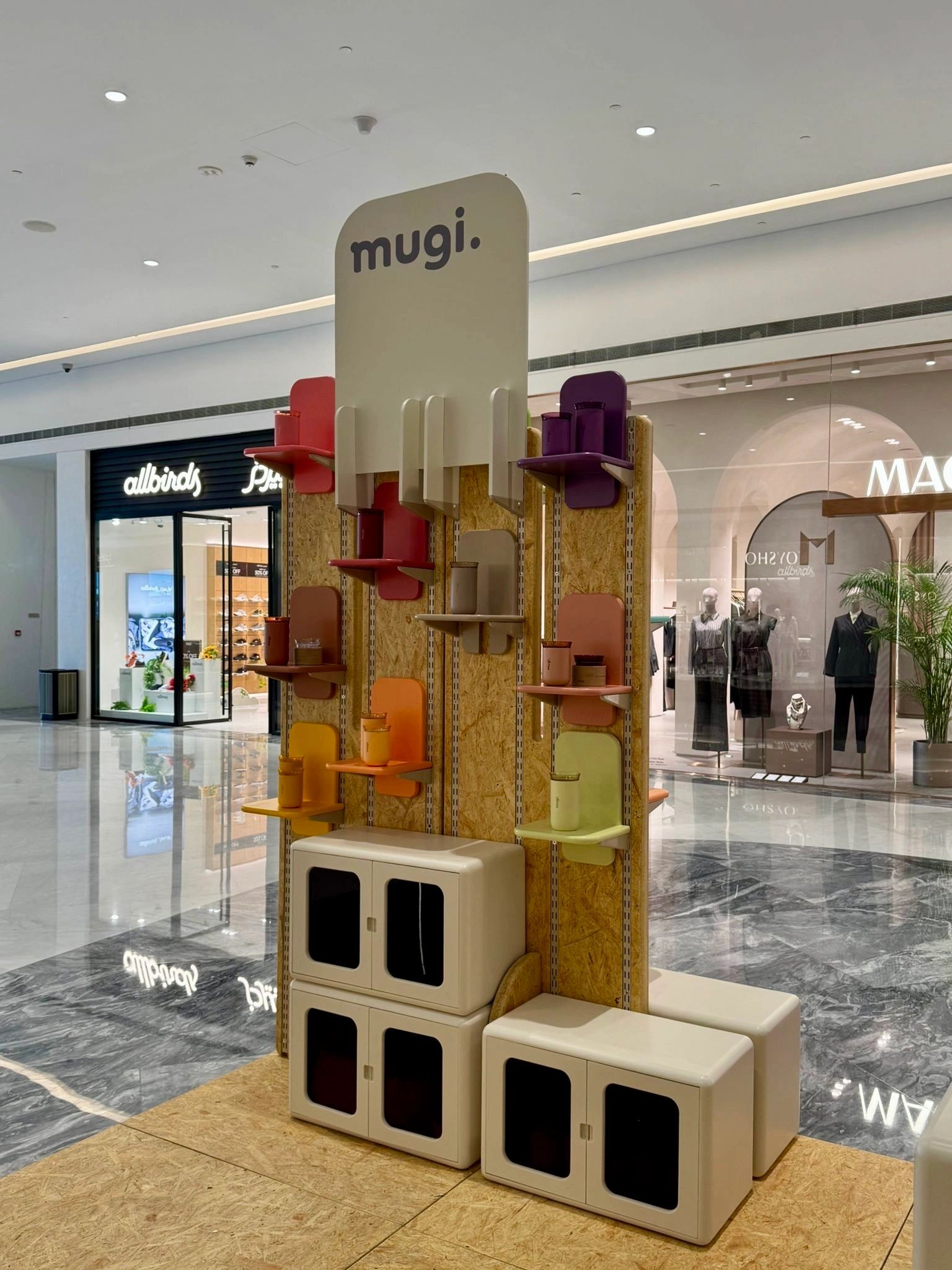 Colorful chairs displayed on a tall rack in a shopping mall.
