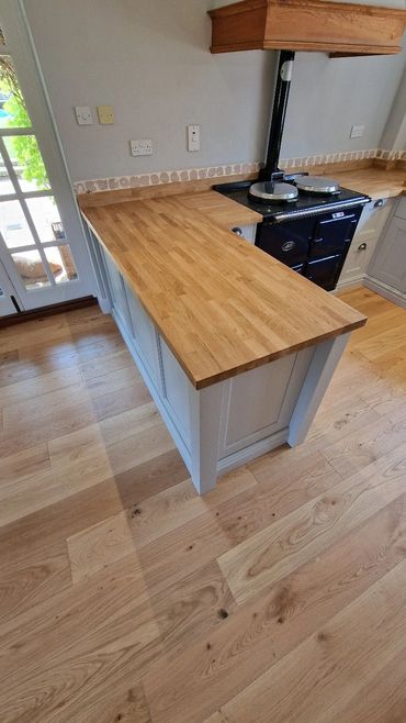 Modern kitchen with wooden countertops and flooring.