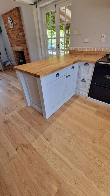 Bright kitchen with wooden floors and a white island countertop.