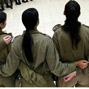 Three soldiers in uniform link arms, showing unity and camaraderie.