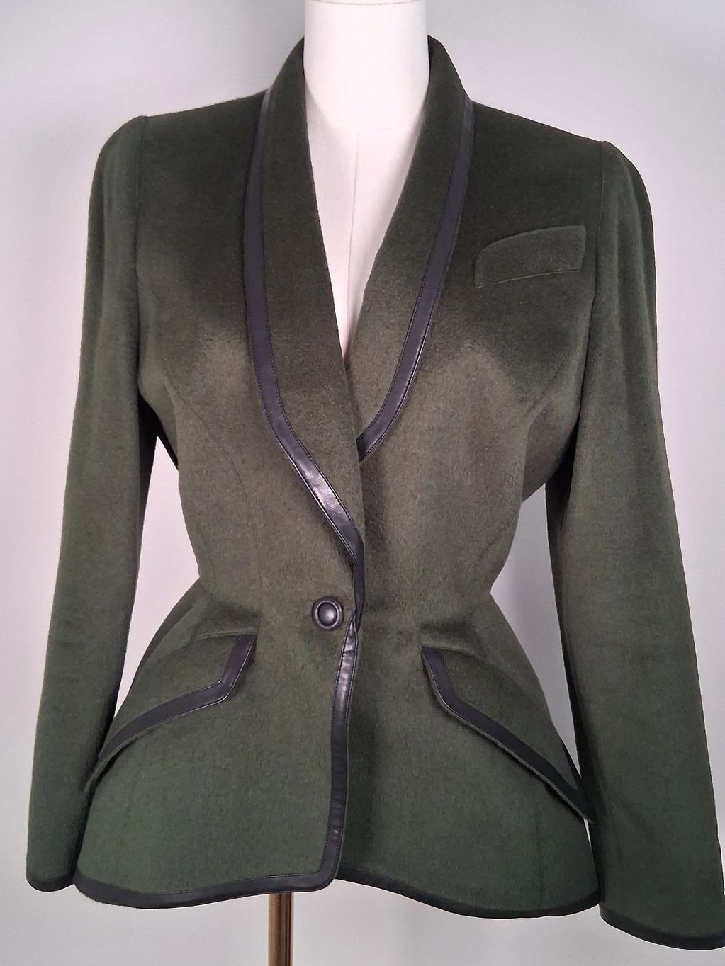 Elegant olive green blazer with black trim and a single button closure.