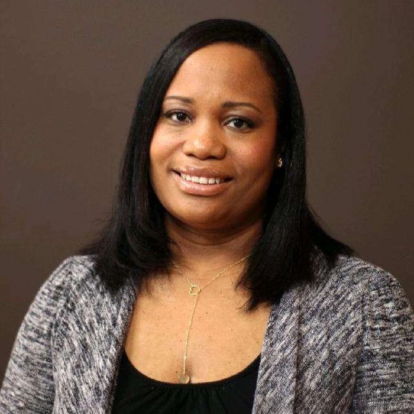 Smiling woman with straight black hair in a grey sweater.