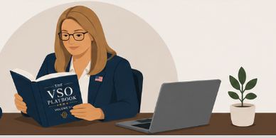 Woman reading VSO playbook at desk with laptop and plant.