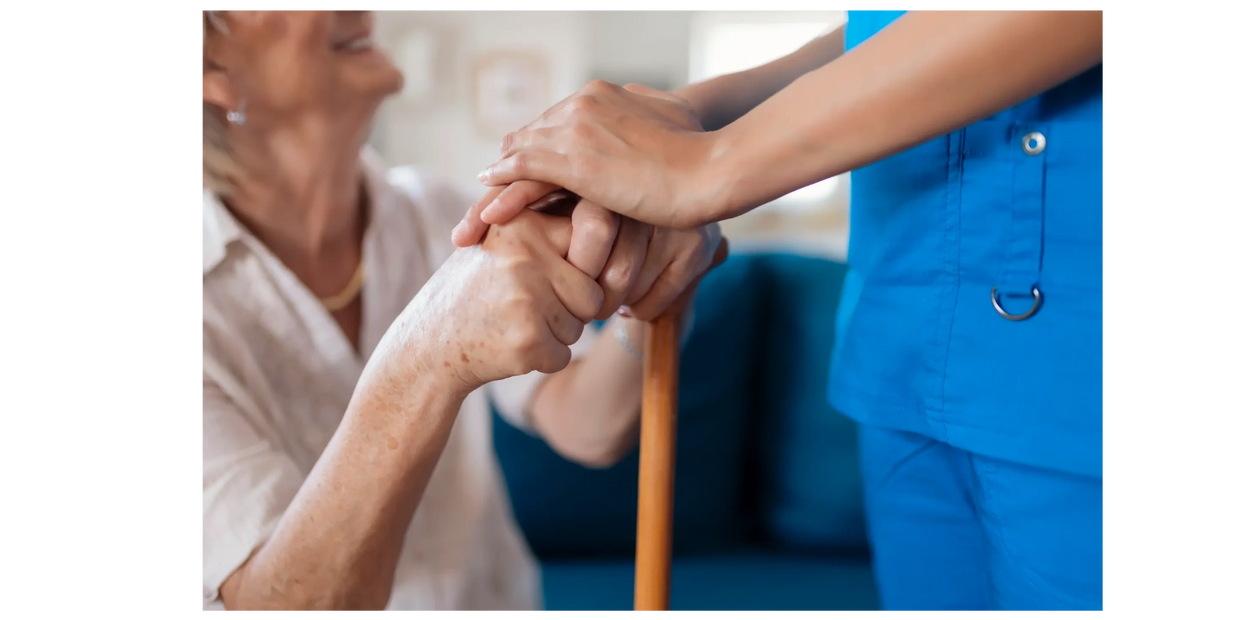 Nurse holding elderly patient's hands, showing care and support.