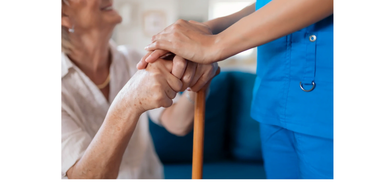 Nurse holding elderly patient's hands, showing care and support.