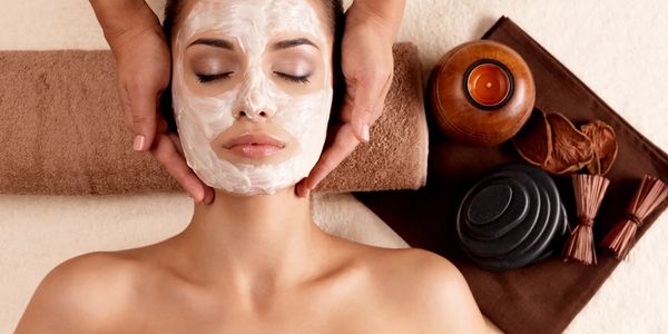 Woman receiving a relaxing facial mask treatment at a spa.