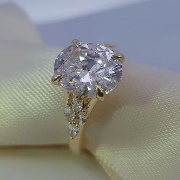 14K yellow gold engagement ring with a 5.0ct oval diamond center, graduated oval and pear side stones