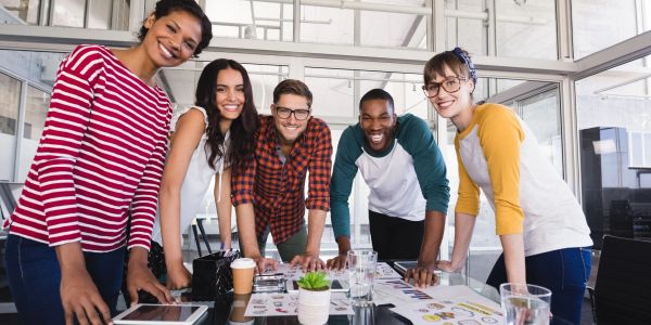 Group of smiling young professionals collaborating at a table.