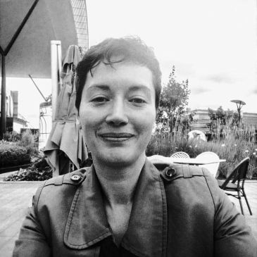 Persona sonriente en un entorno al aire libre.
