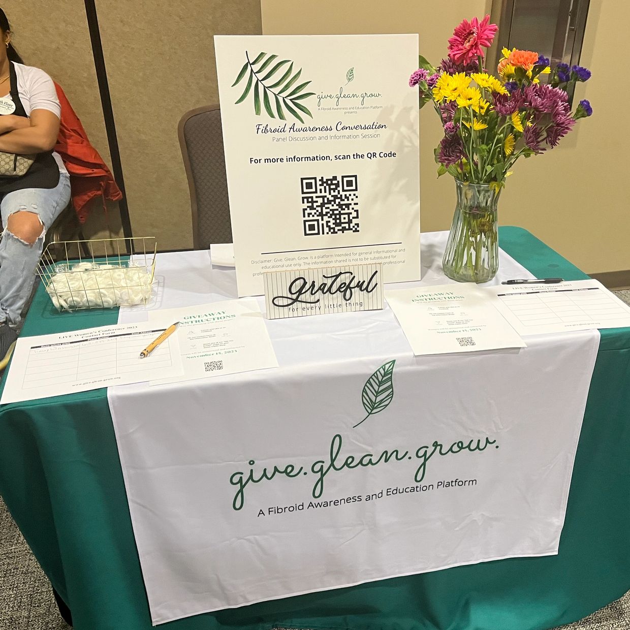 Fibroid awareness table with informational materials and flowers.