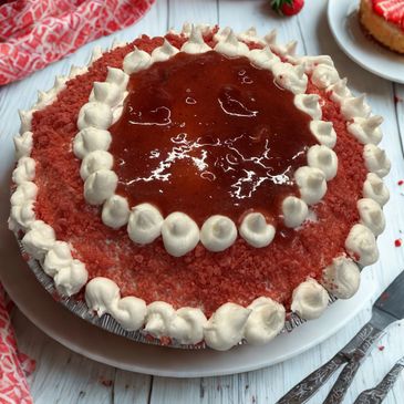 Delicious strawberry cake topped with whipped cream and strawberry glaze.