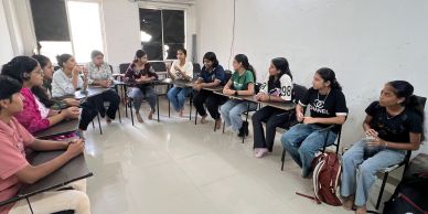 Group of students sitting in a circle in a classroom.