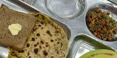 Indian meal with roti, bread, banana, and chickpeas.