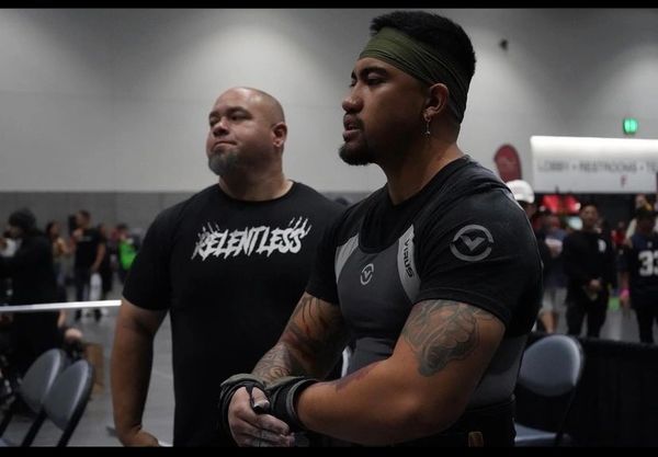 Coach and lifter waiting to step on the platform for his next attempt. Powerlifting 